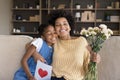 Happy grateful Black mom hugging daughter kid with love