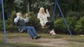 Happy gray-haired man with adult daughter swings on teeterboard