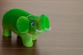 Happy green elephant doll on the wooden table background