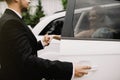 Happy groom helping his beautiful bride out of the wedding car. Royalty Free Stock Photo