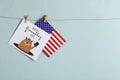 Happy Groundhog Day greeting card and American flag hanging against light background, space for text Royalty Free Stock Photo