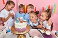 Happy group of children rejoicing at the look of birthday cake Royalty Free Stock Photo