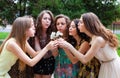 happy group female friends with bouquet of dandelions in the park