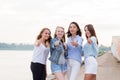 Happy group of female friends with thumbs up outdoor looking at camera and smile