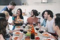 Happy group of friends eating pasta at home dinner party - Cheerful young people having lunch break together - concept Royalty Free Stock Photo