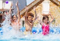 Portrait of three kids splash water in garden pool