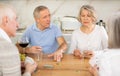 Group of friends playing poker cards and drinking wine at home Royalty Free Stock Photo