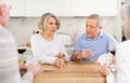 Group of friends playing poker cards and drinking wine at home Royalty Free Stock Photo