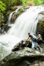 Happy group of Khmer children having fun at the waterfall on rainy day, near Thailand-Cambodia border