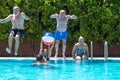 Happy group of mature people enjoying summer and swimming pool, jumping and playing Royalty Free Stock Photo