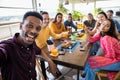 Happy group of multiracial people taking a selfie while having breakfast