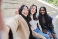 Happy group of multiracial young women taking a selfie portrait smiling at camera. Three diverse girls having fun Royalty Free Stock Photo