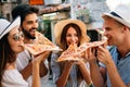 Happy group of people eating pizza outdoors,they are enjoying together. Royalty Free Stock Photo