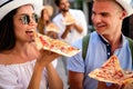 Happy group of people eating pizza outdoors,they are enjoying together. Royalty Free Stock Photo