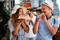 Happy group of people eating pizza outdoors,they are enjoying together. Royalty Free Stock Photo