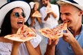 Happy group of people eating pizza outdoors,they are enjoying together. Royalty Free Stock Photo