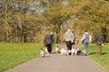 Happy group of people walking with dogs in the park.