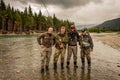 A happy group of sport fly fisherman friends on a beautiful river scene in British Columbia