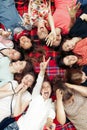 Happy group of women faces in circle laughing and having fun on picnic top view, lying on blanket, joyful moments celebration in
