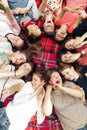 Happy group of women faces in circle laughing and having fun on picnic top view, lying on blanket, joyful moments celebration in