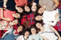 Happy group of women faces in circle posing and smiling on picnic top view, lying on blanket, calm and joyful moments celebration