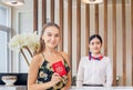 Happy guest and receptionist at hotel reception, Young travellers standing at reception desk with blurred female receptionist