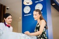 Happy guest and receptionist at hotel reception, Young travellers standing at reception desk with female receptionist standing at