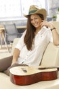 Happy guitar player sitting on sofa Royalty Free Stock Photo