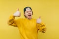 Happy guy in a cap isolated on a yellow background, looks at the camera with a smile on his face and shows a gesture he likes. Royalty Free Stock Photo