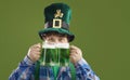 Happy guy celebrating Saint Patrick's Day and enjoying green beer from two big glasses