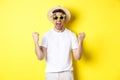 Happy guy going on vacation, winning or celebrating, wearing summer hat and sunglasses. Tourist looking excited Royalty Free Stock Photo