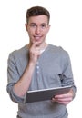 Happy guy in a grey shirt with tablet computer Royalty Free Stock Photo