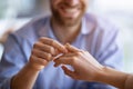 Happy guy holding his fiancee`s hand, putting on engagement ring on her finger, closeup view Royalty Free Stock Photo