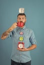Happy guy with mulled wine, clock on blue background. Royalty Free Stock Photo