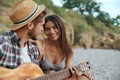 Happy guy play on guitar to beautiful pleased girl Royalty Free Stock Photo