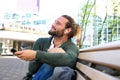 Happy guy sitting on bench listening to music Royalty Free Stock Photo
