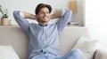 Happy Guy Sitting On Couch Having Lazy Day At Home Royalty Free Stock Photo