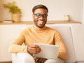 Happy Guy Using Digital Tablet Sitting On Sofa Indoor Royalty Free Stock Photo