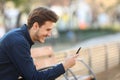 Happy guy using a smart phone in a park Royalty Free Stock Photo