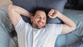 Happy Guy Waking Up Lying In Bed At Home, Top-View Royalty Free Stock Photo