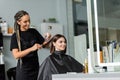 happy hairstylist spraying hair of female Royalty Free Stock Photo