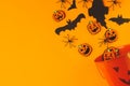 Happy Halloween! Black ghosts, spiders, bats and pumpkins decorations from candy bucket on orange background flat lay. Card Royalty Free Stock Photo