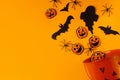 Happy Halloween! Black ghosts, spiders, bats and pumpkins decorations from candy bucket on orange background flat lay. Card Royalty Free Stock Photo