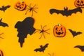 Happy Halloween! Black ghosts, spiders, bats and pumpkins decorations on orange background flat lay. Card template. Stylish Royalty Free Stock Photo