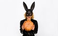 Happy Halloween. Blonde girl in black leather jacket at Halloween party. Angry woman in bunny mask with jack-o-lantern