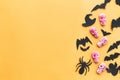 Happy Halloween.  Halloween candy border with skulls, black bats, ghost, spider paper decorations on yellow background. Copy space Royalty Free Stock Photo