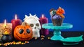 Halloween candyland drip cake style cupcakes with candy on blue background. Royalty Free Stock Photo
