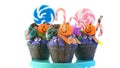 Halloween candyland drip cake style cupcakes with lollipops and candy on white. Royalty Free Stock Photo