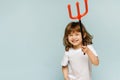 Happy Halloween. A child with a trident on a holiday with a blue background. Preparation for the holiday. Halloween