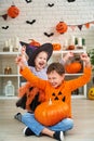 Happy Halloween! Children in Halloween costumes are sitting in a decorated room